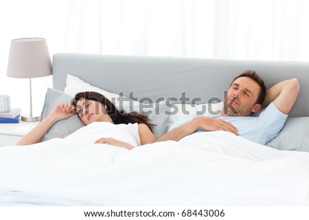Serene couple sleeping on their bed in the morning at home
