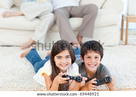 Children playing video games while parents are talking at home