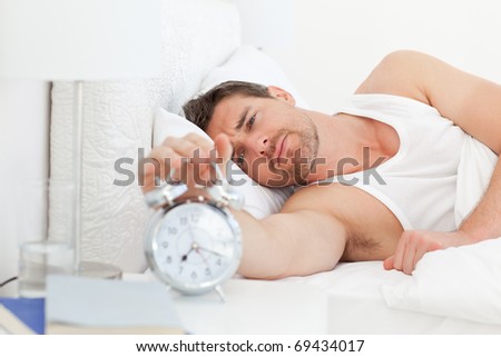 A unhappy man in his bed before waking up in his bedroom