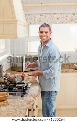 Handsome man cooking in the kitchen at home