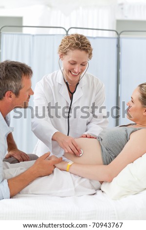 Pregnant woman with her husband listening to the nurse