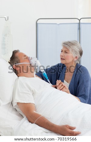 Old women taking care of her husband at home