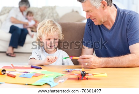 Little boy drawing with his grand father at home