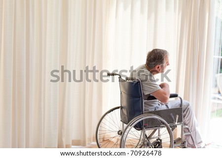 Man in his wheelchair looking out the window