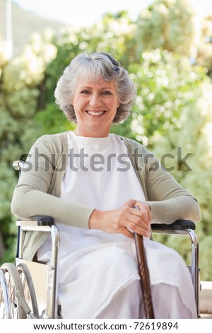 Elderly woman with her walking stick at home