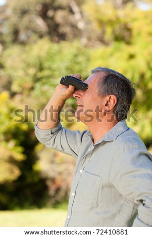 Senior man looking at the sky with his binoculars