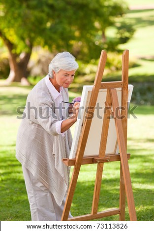 Mature woman painting in the park