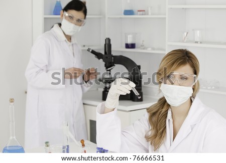 Dark-haired and blond-haired scientists carrying out an experiment in a lab