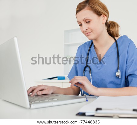 Young female doctor working on her laptop in her office