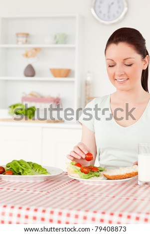 Cute woman ready to eat a sandwich for lunch in her kitchen