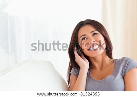 dark-haired woman phoning in living room