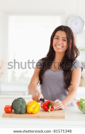 Charming woman cooking vegetables while standing in the kitchen