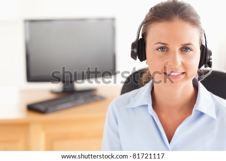 Office worker wearing a headset posing  in her office