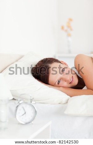 Close up of a Red-haired woman lying in bed looking into the camera in the bedroom