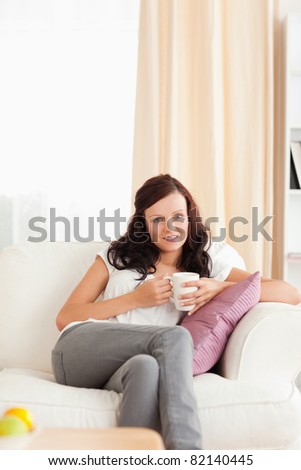 Woman drinking coffee in her living room
