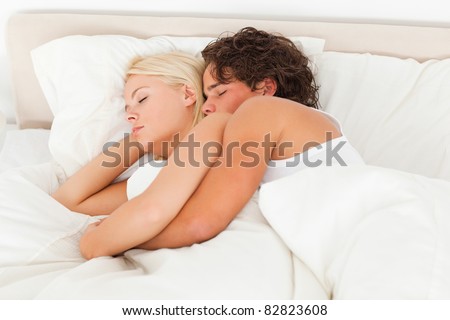 Calm couple hugging while sleeping in their bedroom