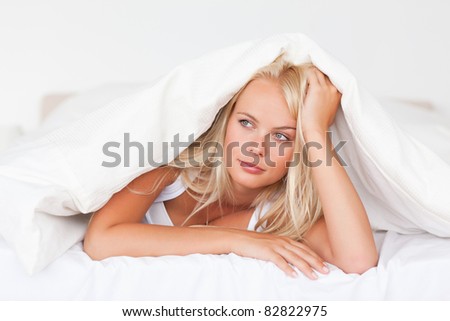Woman under a duvet in her bedroom
