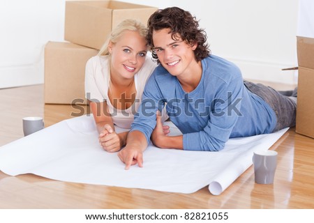 Couple getting ready to move in a new house looking at the camera
