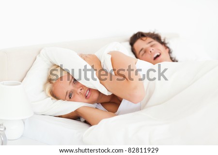 Angry woman awaken by her husband\'s snoring in their bedroom