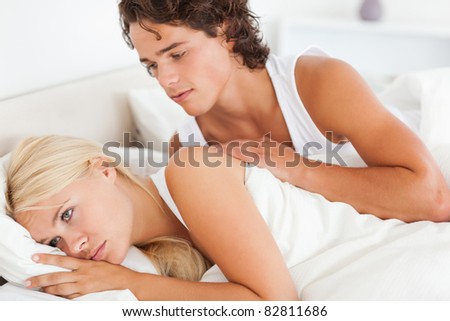 Man trying to be forgiven by his fiance in their bedroom