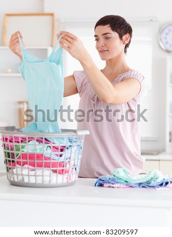 Cute Woman folding clothes in a utility room