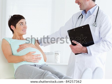 Pregnant woman lying down while talking to her doctor