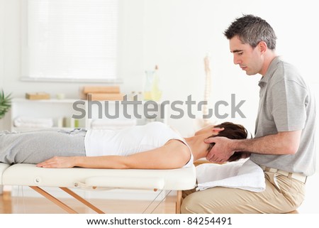 A masseur is stretching a woman\'s head