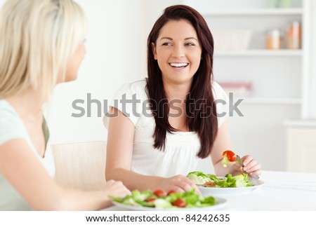 Portrait of laughing Women eating salad in a kitchen