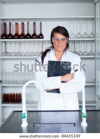 Portrait of a female scientist holding a clipboard in a laboratory