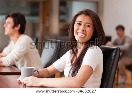 Laughing woman having a tea in a coffee shop