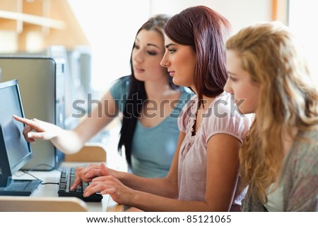 Cute fellow students working together in an IT room