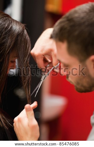 Portrait of a male hairdresser cutting hair with scissors