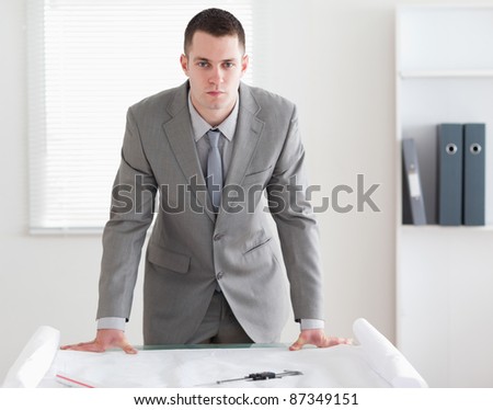 Architect standing behind a table with plans in front of him
