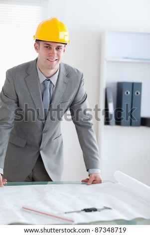 Smiling and standing architect with helmet on