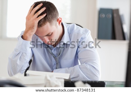 Young businessman stressed while doing his accounting
