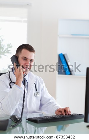 Smiling doctor talking with patient on the telephone