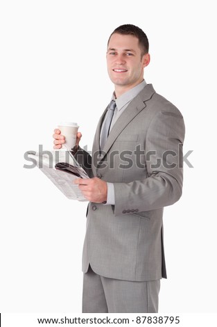 Portrait of a businessman holding a newspaper and a cup of tea against a white background