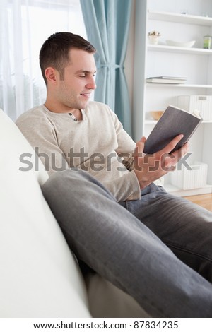 Portrait of a smiling man reading a book in his living room