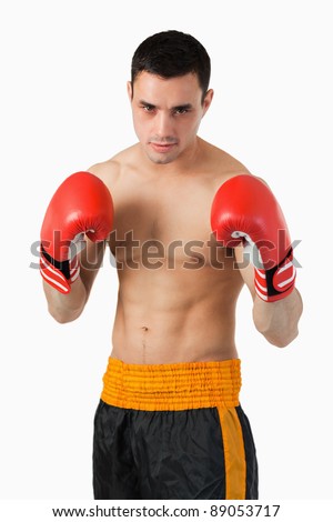 Young boxer in fighting stance against a white background