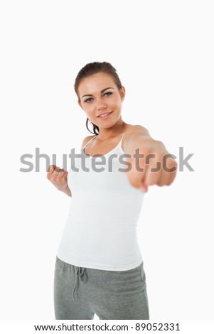 Young female martial arts fighter attacking with her left against a white background