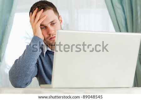 Young businessman annoyed by his laptop in his homeoffice