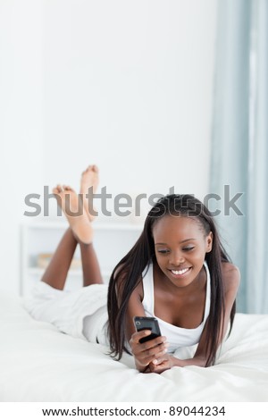 Portrait of a woman sending text messages in her bedroom