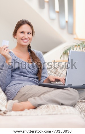 Portrait of a happy woman shopping online in her living room