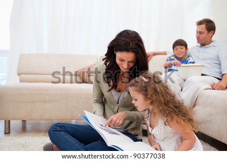 Mother showing photo album to her daughter