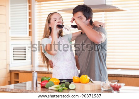 Lovely couple drinking red wine in their kitchen
