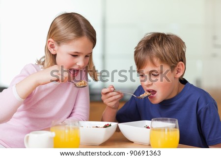 Young children having breakfast in a kitchen