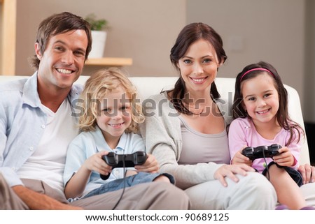 Smiling family playing video games together in a living room