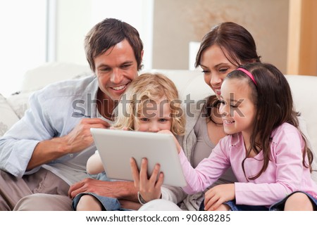 Delighted family using a tablet computer in a living room