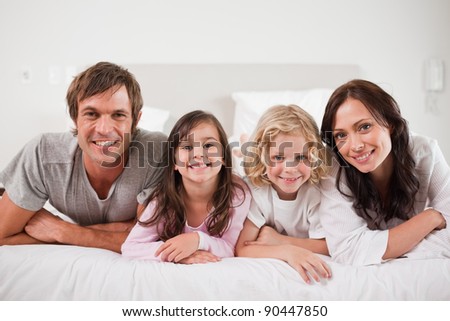 Cheerful family lying in a bed together