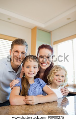Happy smiling family standing behind the kitchen counter
